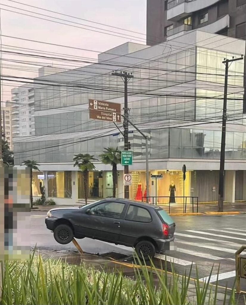 Carro sobe a calçada e fica pendurado na barra de proteção em Bento Gonçalves.